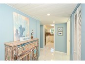 Entry with utility and pantry on the right; access to third bedroom on the right. Kitchen and green belt views straight ahead - Condo for sale at 450 Gulf Of Mexico Dr #B107, Longboat Key, FL 34228 - MLS Number is A4520786